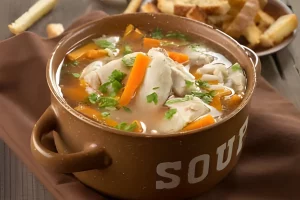 Variety of chicken broth options displayed on a kitchen counter