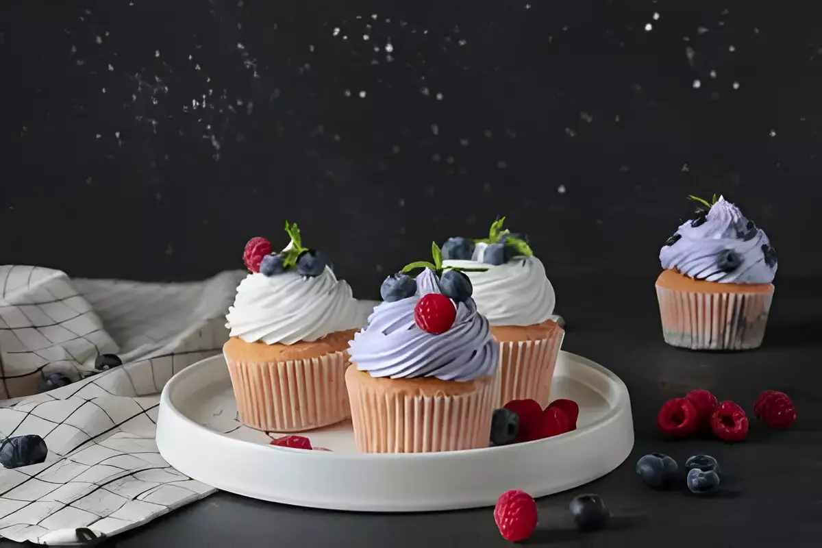 Hand decorating gluten-free cupcakes with colorful sprinkles