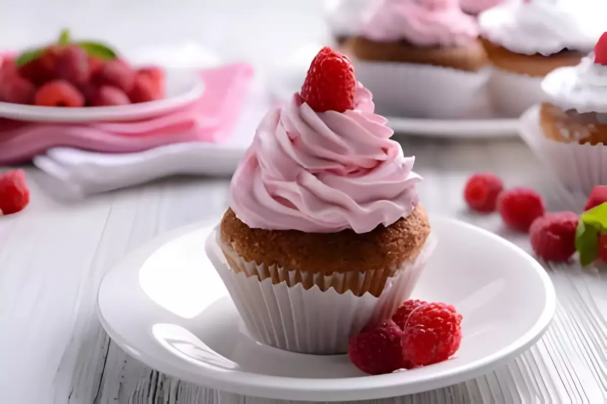 Baker piping frosting onto mini cupcakes