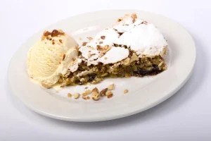 Slicing a homemade Pecan Cream Pie revealing creamy filling