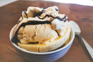 Slice bananas layered with vanilla wafers in a glass bowl - Banana Pudding Dessert