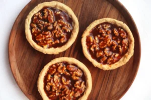 Baker carefully arranging pecans atop pie filling