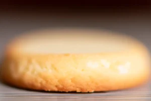 A close-up of a perfectly baked sugar cookie, golden around the edges with a soft center.