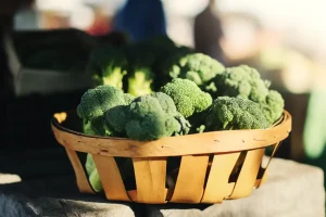 A basket of fresh broccoli at a farmer's market under the sunlight